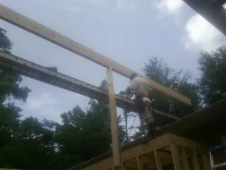 Carpenter setting a ridge beam over a new addition frame — Ice Dam Removal by Roofing Brothers in Kittredge