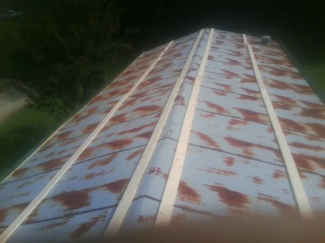 Rusted metal roof panels with new wood purlins before replacement — Storm Damage Roof Repair in Kittredge by Roofing Brothers