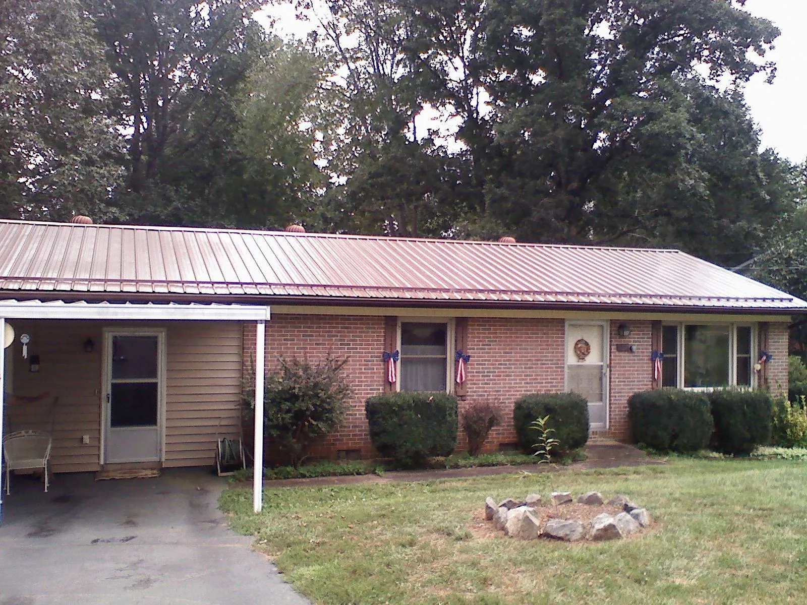 Bronze metal roof and carport on a brick ranch home — Roof Repair work by our crew in Kittredge
