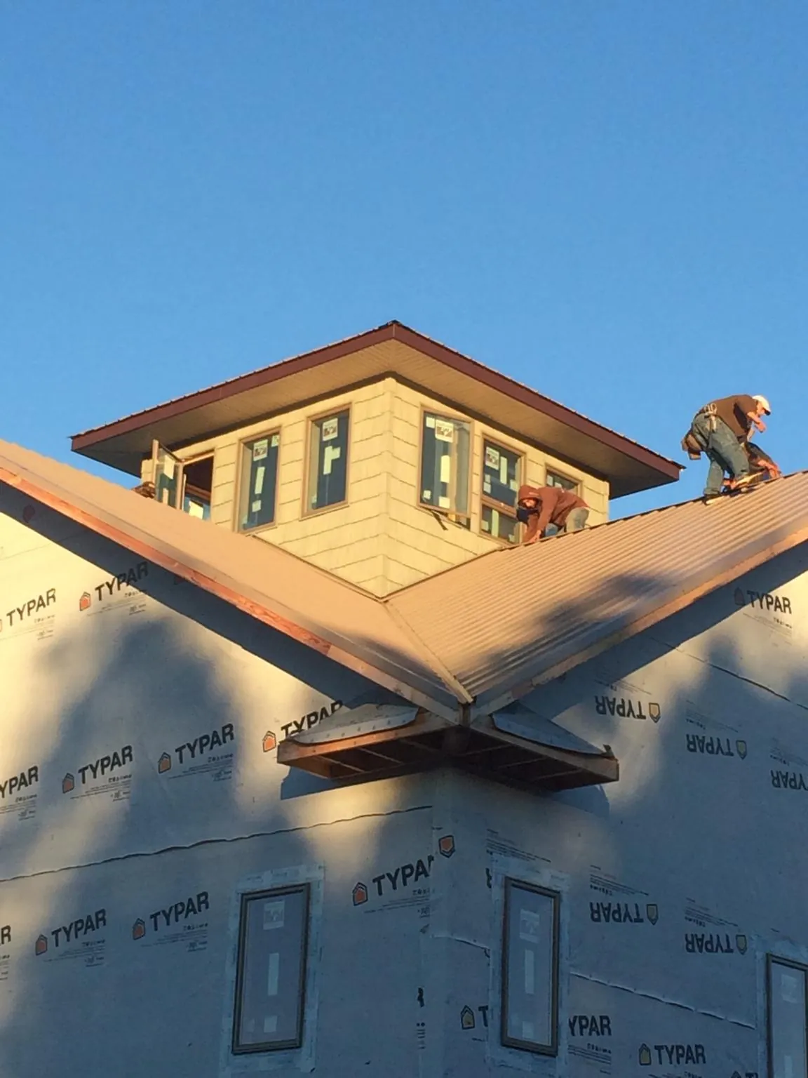 Roofers working around a rooftop cupola on a new metal roof at sunset — Roof Waterproofing in Kittredge by Roofing Brothers